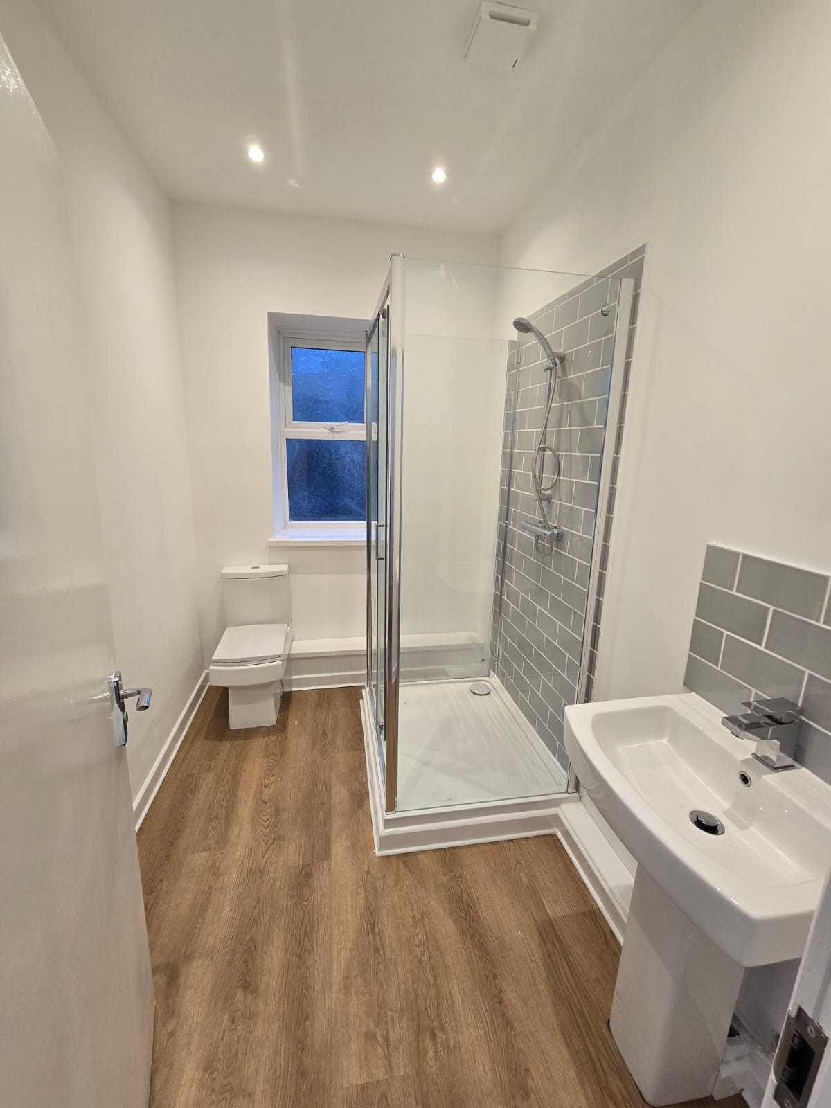 Modern subway tile bathroom with wood flooring